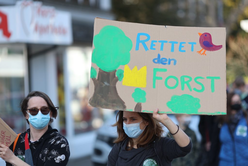 "Rettet den Forst" steht auf einem Demoplakat, das eine Frau hochhält.